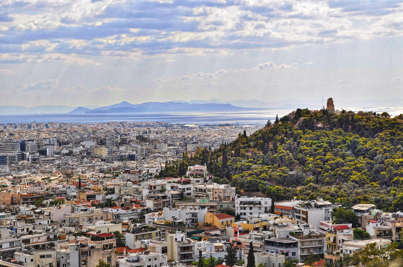 Stunning view of Athens, with the Acropolis in the background and ancient ruins in the foreground, capturing the beauty of both historical landmarks and modern life in the city.
