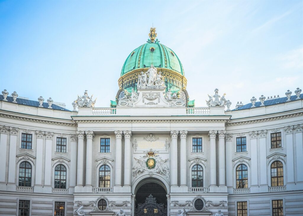 Exterior view of the Hofburg Palace in Vienna, showcasing the iconic green dome and intricate architecture.